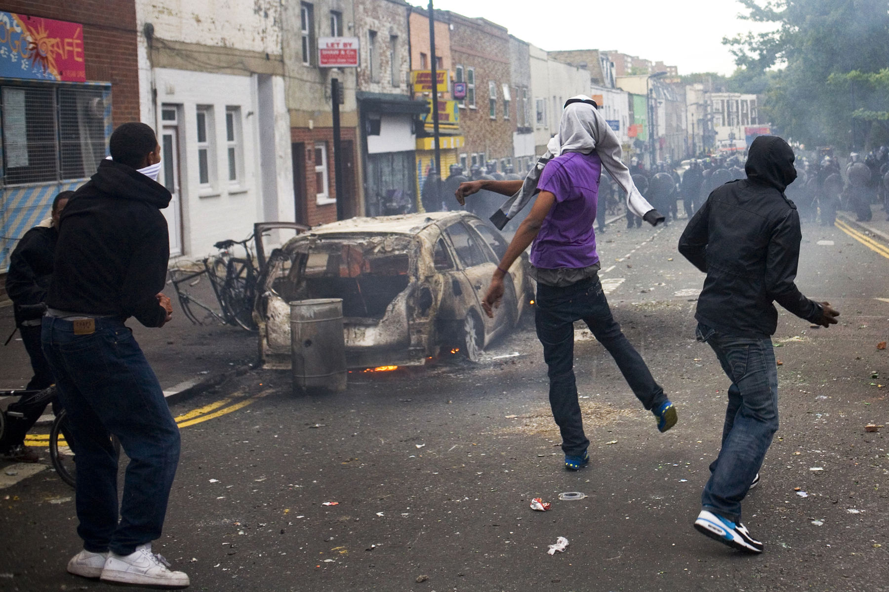 Rioters throw bricks and bottles at the police on Clarence Road in the Hackney area of London.